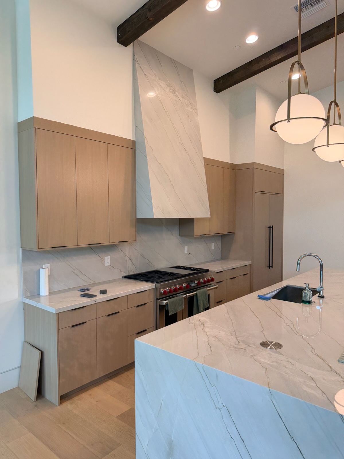 Modern oak kitchen with integrated cabinetry and stone range hood