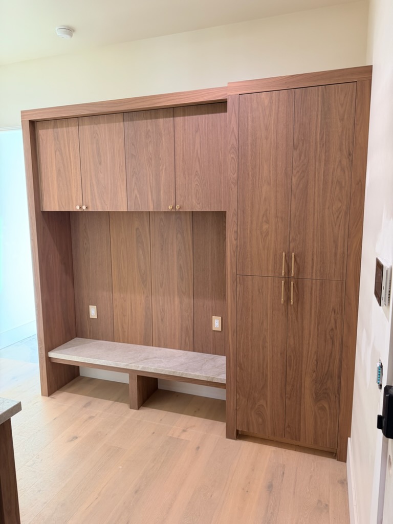 Walnut mudroom with storage bench and tall cabinet