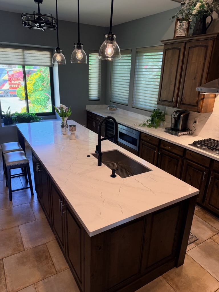 Dark wood kitchen cabinetry with a white stone island