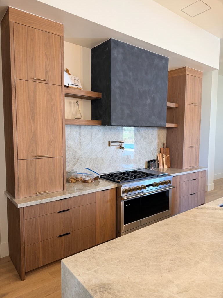 Walnut tall cabinets flanking a professional range with stone hood